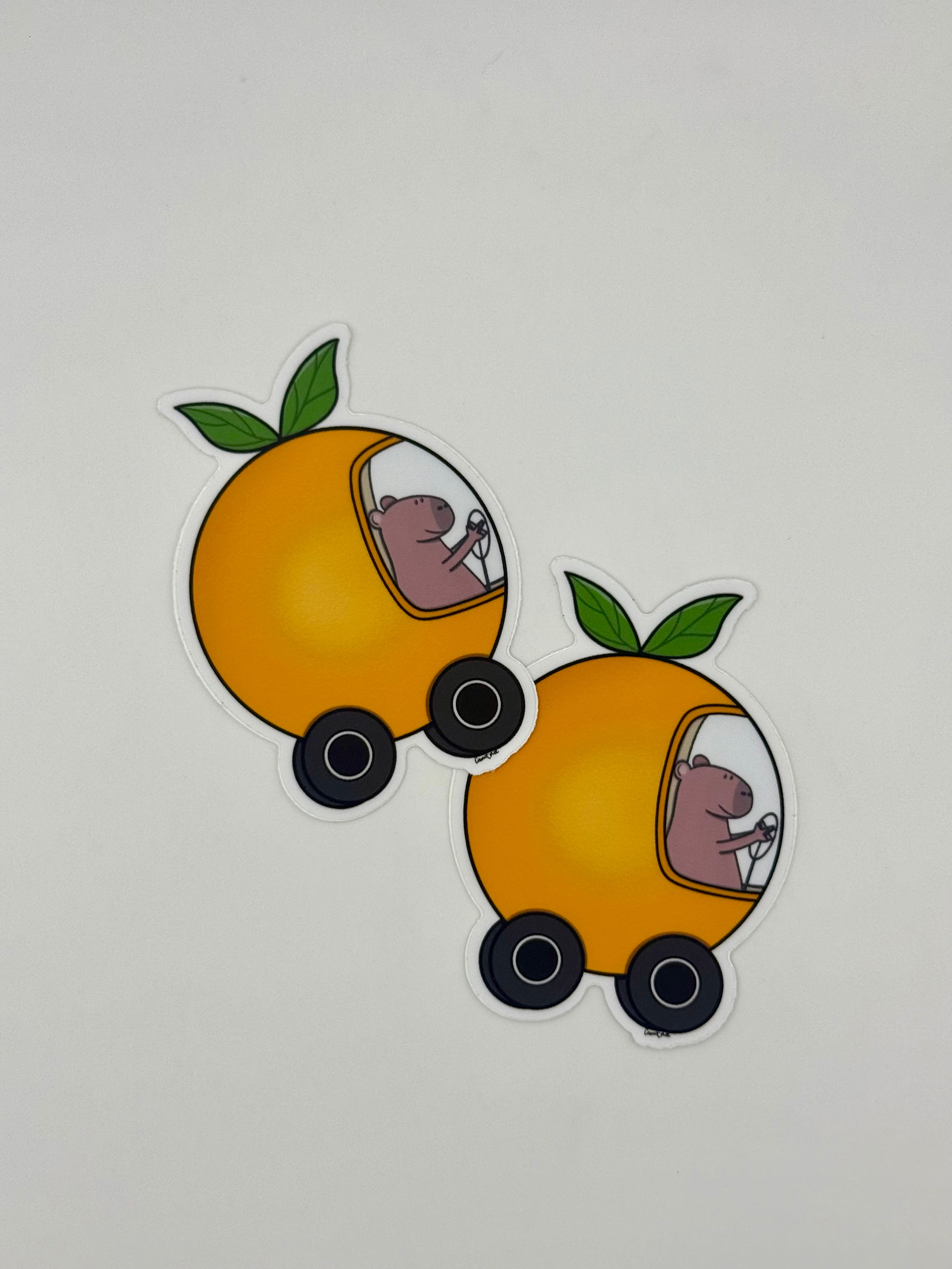 Capybara driving an orange car sticker