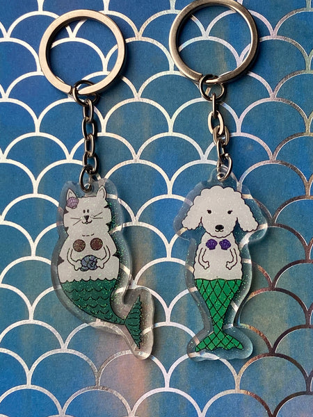 mermaid acrylic keychains - one is a  mermaid cat with glitter and one is a dog mermaid with glitter